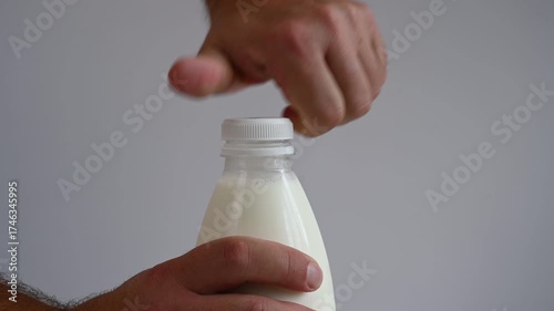 A man opens a bottle of milk. 