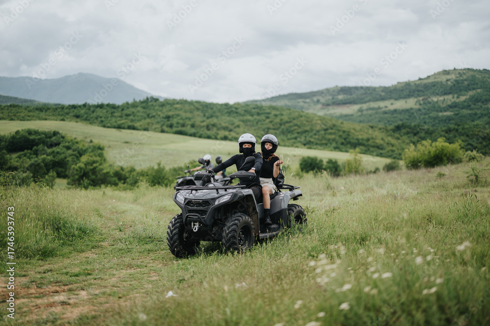 Fototapeta premium Riders on an all-terrain vehicle exploring beautiful green meadows with scenic mountain views. The image captures the essence of adventure, teamwork, and freedom amidst nature's tranquility.