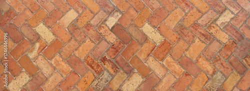 Alte terrakottafarbene Klinkersteine im Fischgrätmuster - Panorama Hintergrund