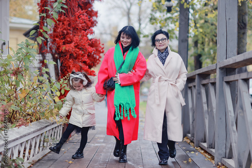 family on a walk, women, daughter, mother, grandmother and granddaughter in the autumn city outside