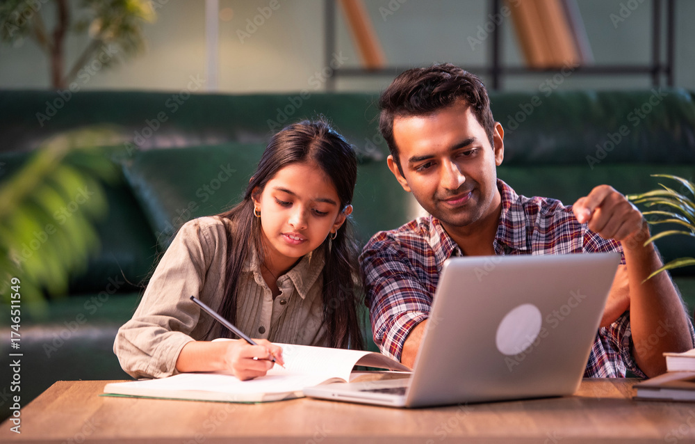 Fototapeta premium Indian Father helping daughter study on laptop, family learning and bonding at home
