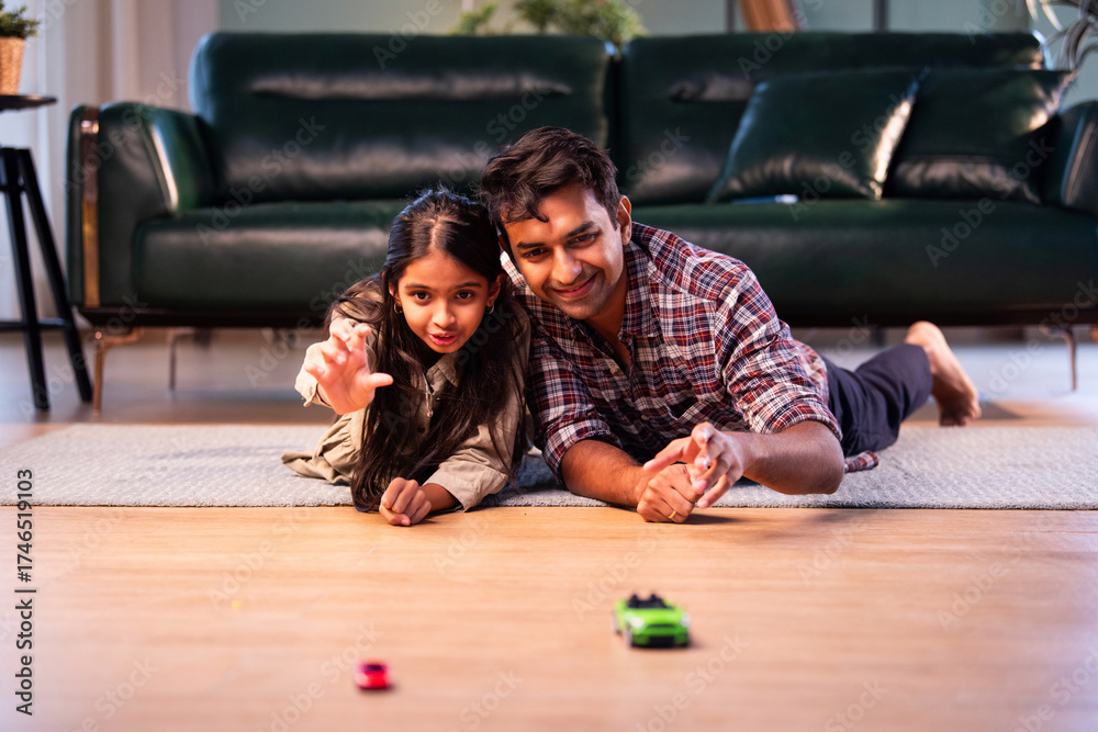 Fototapeta premium Indian father and daughter playing toy car race, sharing quality playful time at home