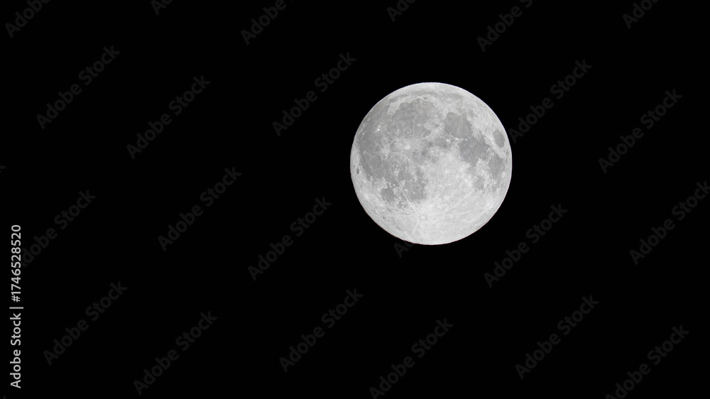 Naklejka premium High-resolution photograph of the Full Moon with sharp texture and craters visible against a deep black night sky. A perfect celestial image for themes of science, space, nighttime, and mystery.