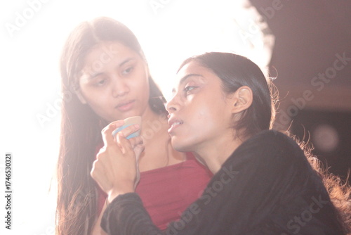 Nepali Indian girl doing makeup for friend in soft natural light, artistic beauty portrait photography
