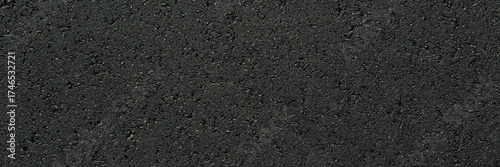 New dark black asphalt background. Closeup. Wide banner. Empty place for text. Top down view.