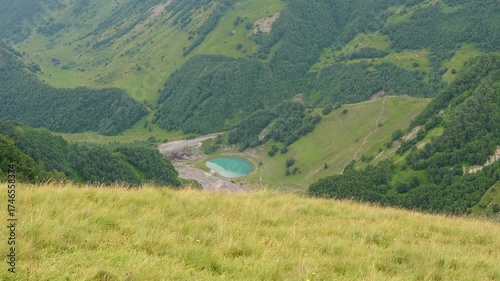 Panoramic view of mountainous terrain and beautiful blue lake in Gudauri, Georgia. Natural beauty of Georgia. Travel concepts, mountainous terrain, natural attractions