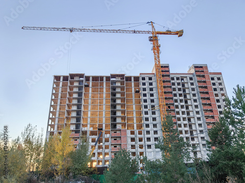 Construction of high rise residential building with tower crane in urban setting