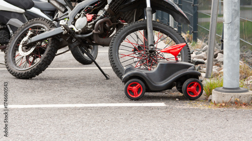 Motorcycle and pedal car parked side by side