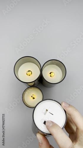 Female hands sorting through Christmas decoration balls candles on a light background, close-up, top view