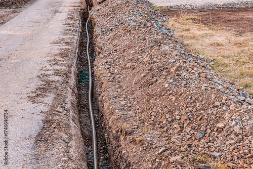 Billede på lærred Trench excavating for installing various utility pipes and cables, showing the o