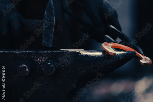 A closeup captures one heated horseshoe, red and glowing, held in the smith’s hand. The iron hammer strikes with force, echoing ancient industry in a metal manufactory shaped by timeless craft.