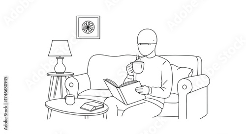 A person relaxes on a sofa reading and drinking from a mug