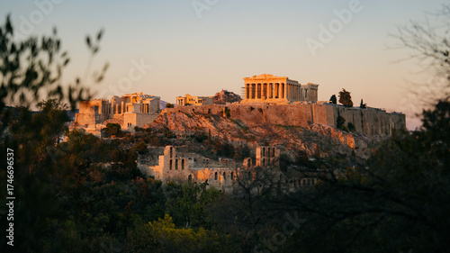 Beautiful view of the Acropolis of Athens at sunset, with the Parthenon temple glowing in warm golden light. The historic landmarks of Greece’s capital, A timeless symbol of Greek civilization 