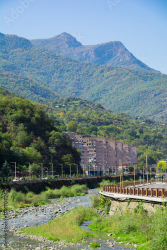 A beautiful city with beautiful buildings and a river. The river flows through the city. A beautiful mountain and river. The city of Kapan in Armenia. A small, cozy town with river and mountain views