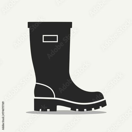 Black rubber boot against white background perfect for construction topics. Showing rubber boot design, simple silhouette and thick sole, this footwear item is built for protection.