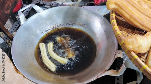 The process of frying fried bread or cakwe. Also known as Youtiao or Cakoi, this food is very popular among Chinese Indonesians, Malaysians, and Singaporeans as a breakfast dish.