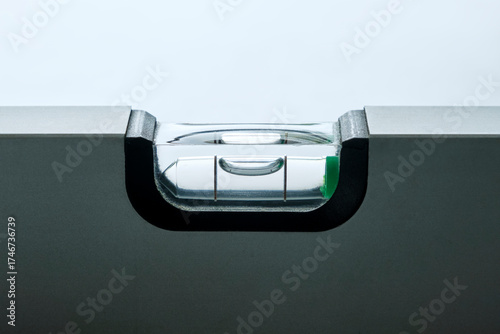 Close-up of grey metal spirit level with bubble against a white background. Image with copy space. Balance and stability concept.	