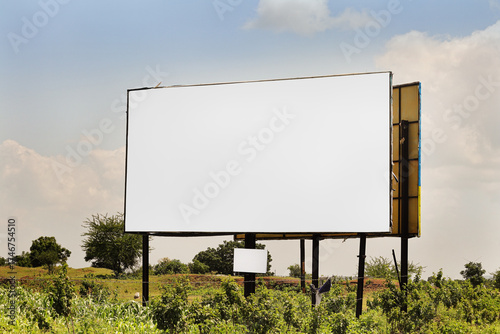 Billboard on rural area of India, outdoor advertising, mockup billing board in front of green tree and Blank white background for branding design large hoarding. Outdoor advertising construction.india
