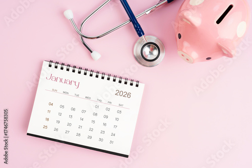 January 2026 desk calendar and stethoscope with piggy bank, Savings for health concepts.