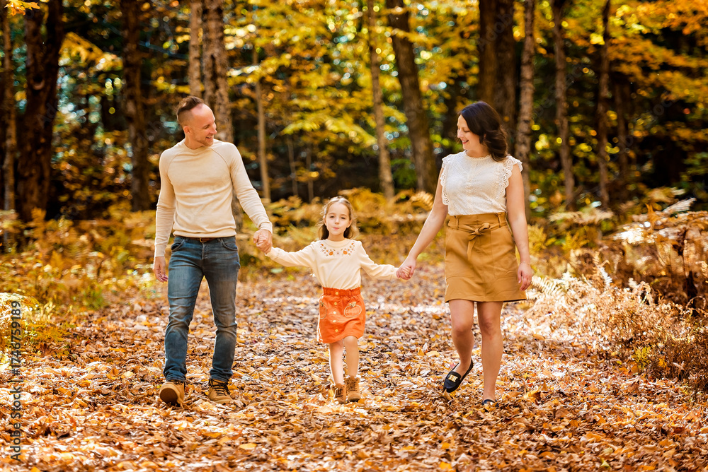 Fototapeta premium Mature family with daughter on a walk in autumn forest.