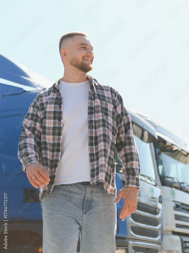 Fototapeta premium Truck driver smiling looking away next to vehicle