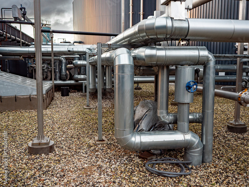 Detailed view of a modern biogas installation in rural Denmark, showing tanks, pipes, and clean energy infrastructure producing renewable gas from organic waste from farms