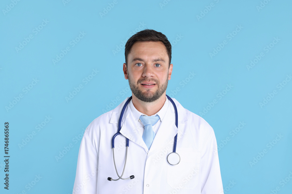 Fototapeta premium Pediatrician with stethoscope on light blue background