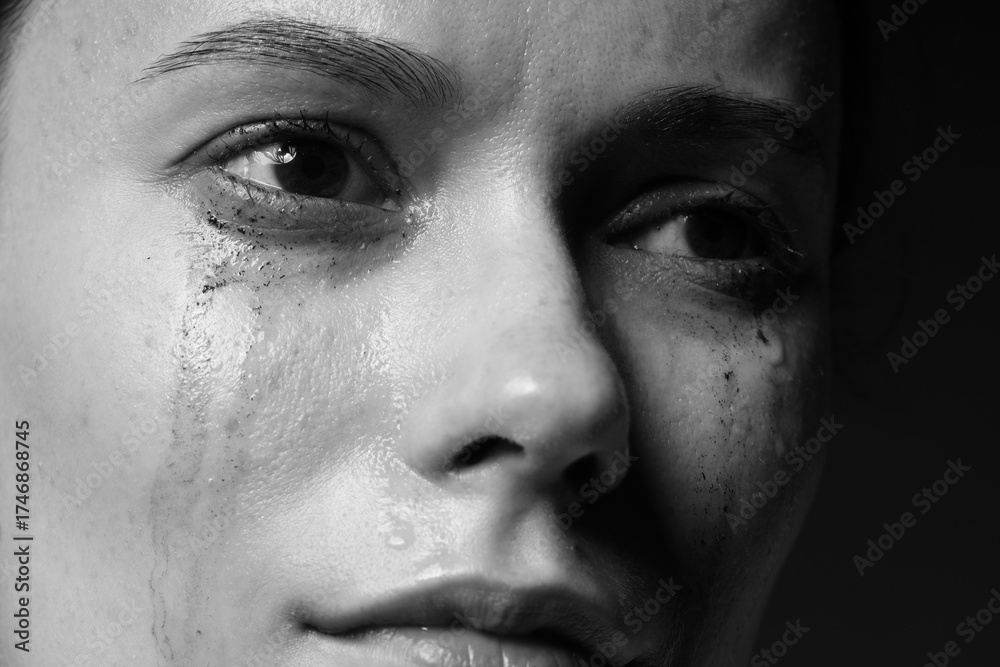 Fototapeta premium Sad woman crying on dark background, closeup. Black and white effect