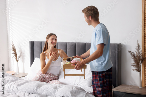Foto Man bringing romantic breakfast to his girlfriend in bed at home