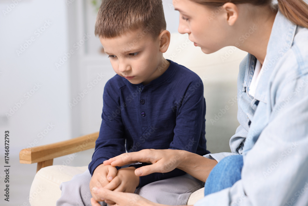 Obraz premium Mother supporting and holding hands with her upset son at home, closeup
