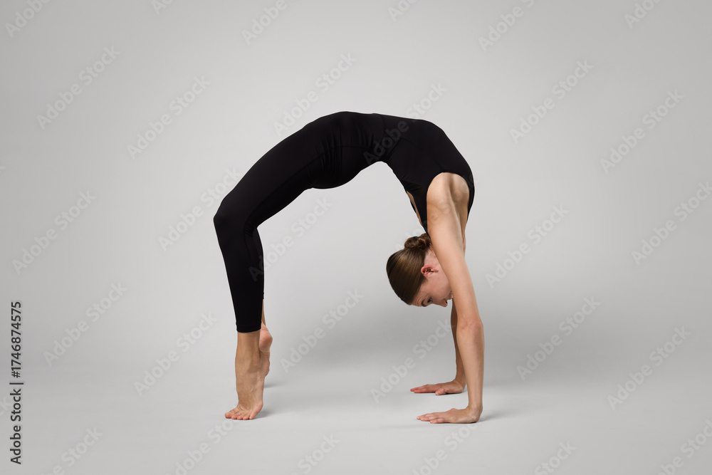 Naklejka premium Woman doing gymnastic exercise on light grey background