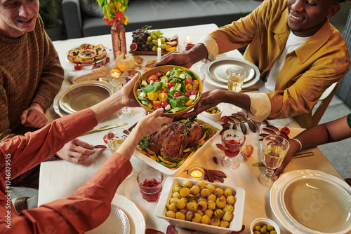 Fényképezés Group of young adult multiethnic friends sitting around dining table sharing foo