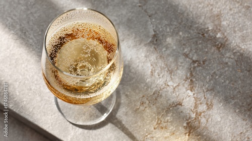 Close-Up of a Sparkling Champagne Glass on a Marble Surface with Elegant Light Reflections