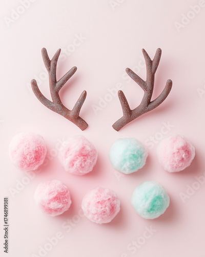 Minimalist Christmas reindeer antlers flat lay with cotton candy spheres and pastel ornaments