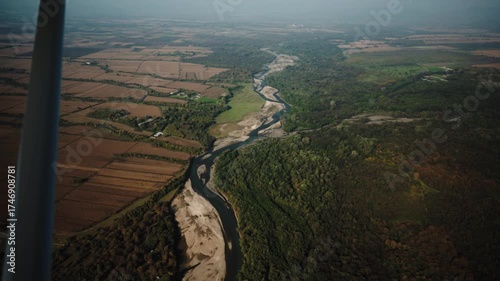 A small plane flying over colorful autumn landscapes at sunset