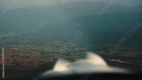 A small plane flying over colorful autumn landscapes at sunset