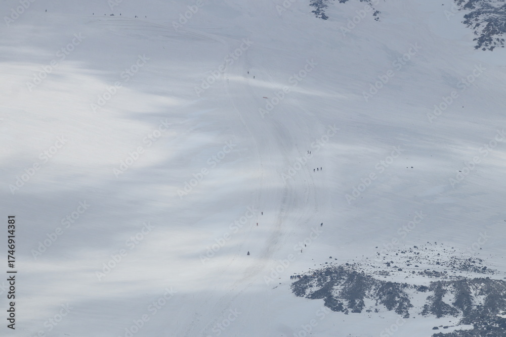 Obraz premium A chain of climbers ascending Mount Elbrus from a height of 4,100 m.