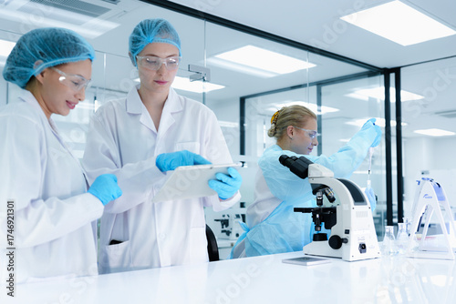 Εκτύπωση καμβά scientists collaborate on assay development, with one performing a critical pipetting step while the other documents the procedure on a tablet for protocol validation under GxP guidelines