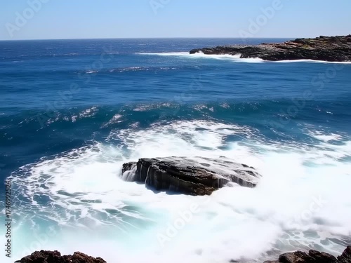 Ocean waves crashing on rocky shoreline, creating mesmerizing white water patterns and sea splashes