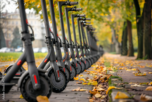 Shared electric scooters neatly lined up in scenic green city park