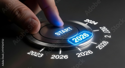 Finger pressing start button on a dial with the year 2026 highlighted