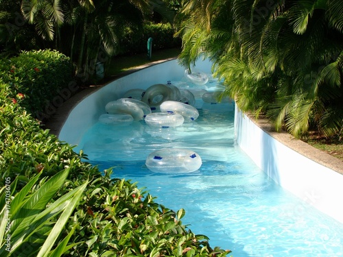 Fototapeta lazy river pool in tropical resort with empty tubes