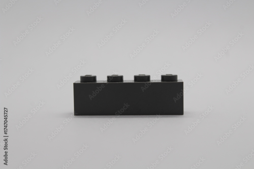 Fototapeta premium Black Lego brick piece isolated on a white background 