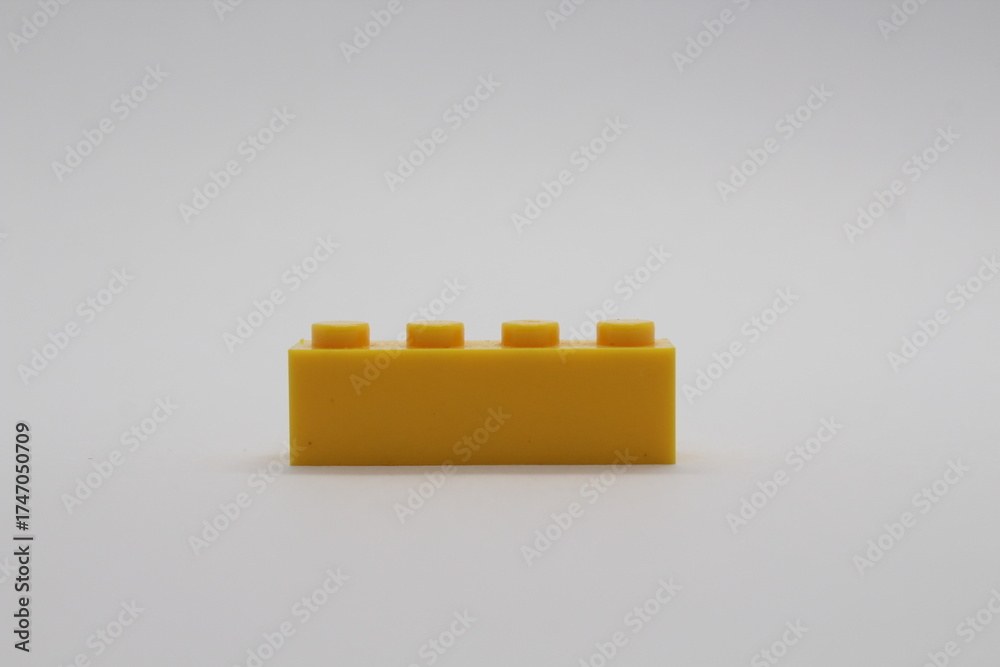 Naklejka premium Yellow Lego brick piece isolated on a white background