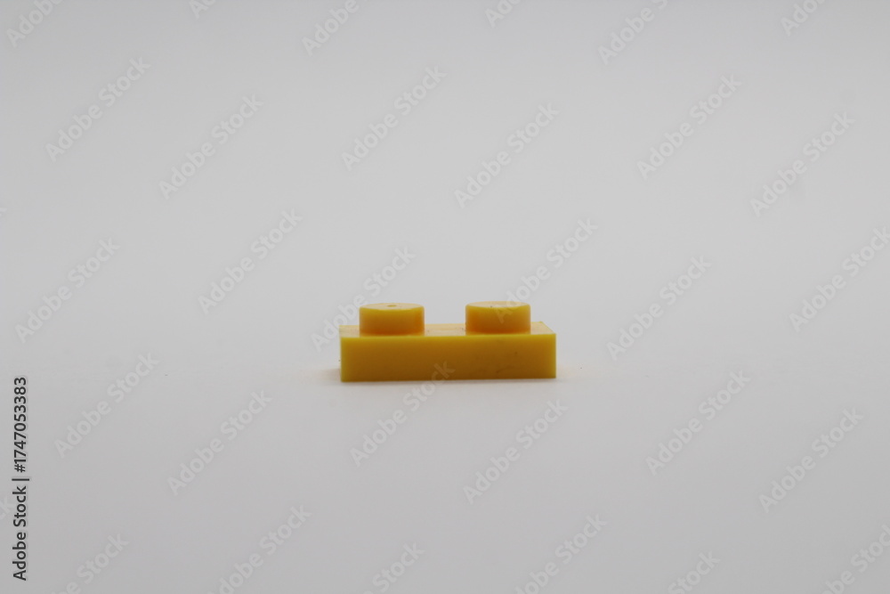 Obraz premium Yellow Lego brick piece isolated on a white background 