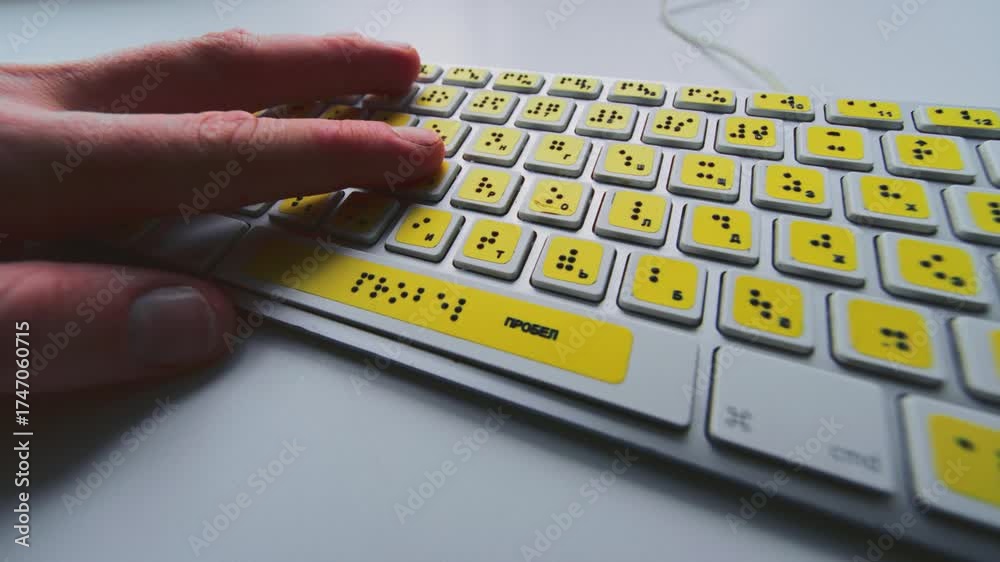 Computerized Braille Computer keyboard with braille font alphabet. Blind person is typing ...
