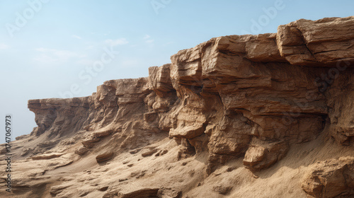 Wallpaper Mural Eroded sandstone cliffs form a rugged, layered landscape against a clear, pale blue sky, showcasing the natural beauty and geological formations of arid terrain. Torontodigital.ca