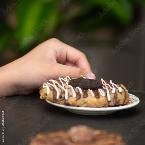 Chocolate dessert on plate served with hand holding fork.