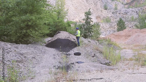 Construction worker inspecting material amount using tablet on construction site