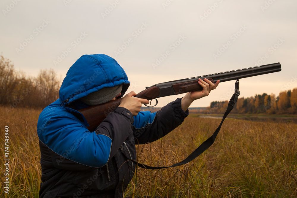 Naklejka premium Duck hunting . A man with a gun on a duck hunt.